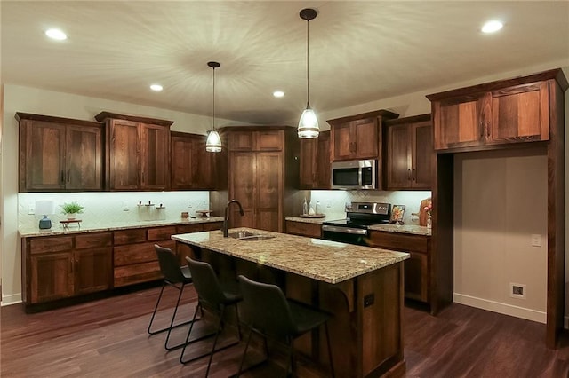 kitchen with dark hardwood / wood-style flooring, light stone countertops, pendant lighting, and stainless steel appliances