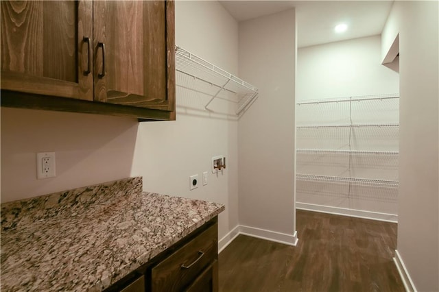 clothes washing area with hookup for an electric dryer, hookup for a washing machine, and dark wood-type flooring