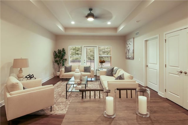 interior space featuring a raised ceiling, ceiling fan, and dark hardwood / wood-style flooring