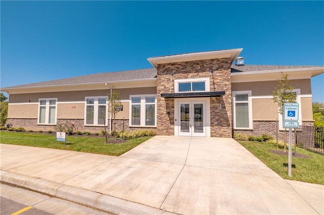 view of front of property featuring french doors and a front lawn