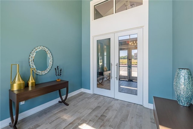 doorway to outside with french doors, high vaulted ceiling, and hardwood / wood-style floors