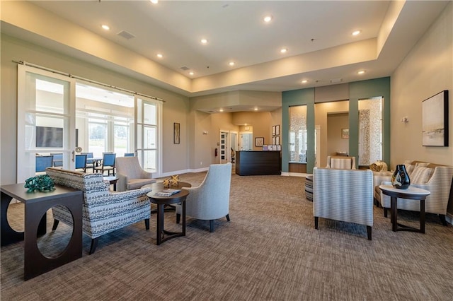 carpeted living room featuring a raised ceiling