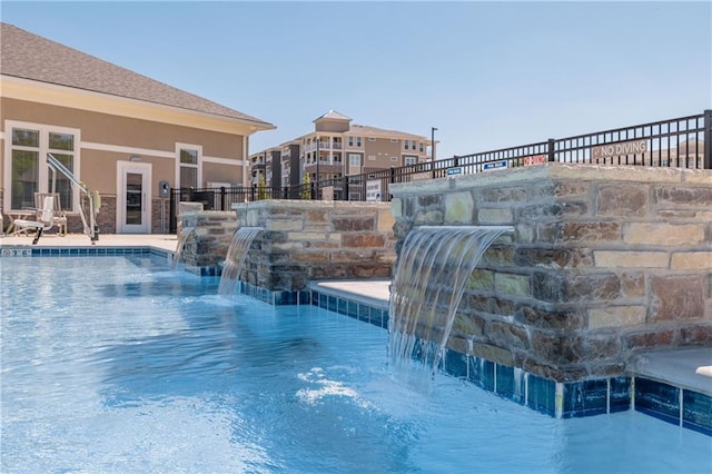 view of swimming pool with pool water feature