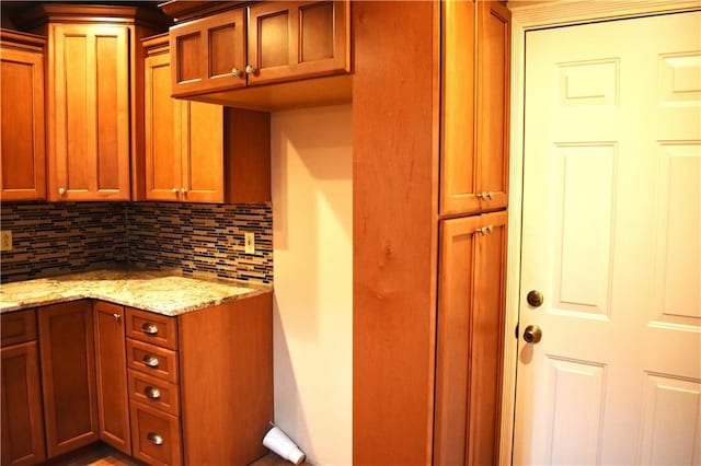 kitchen with decorative backsplash and light stone counters