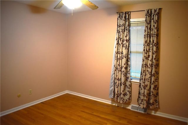 spare room with hardwood / wood-style floors and ceiling fan