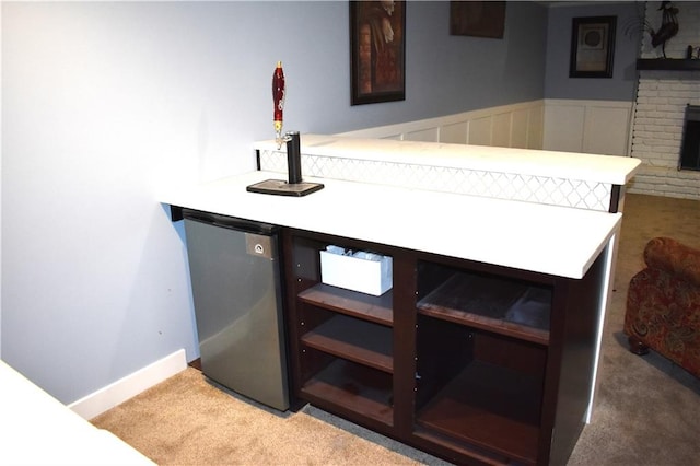 bar with stainless steel refrigerator, a fireplace, and carpet floors