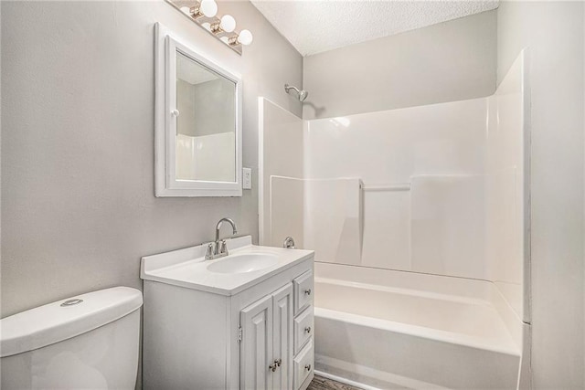 full bathroom with vanity, a textured ceiling, toilet, and shower / washtub combination