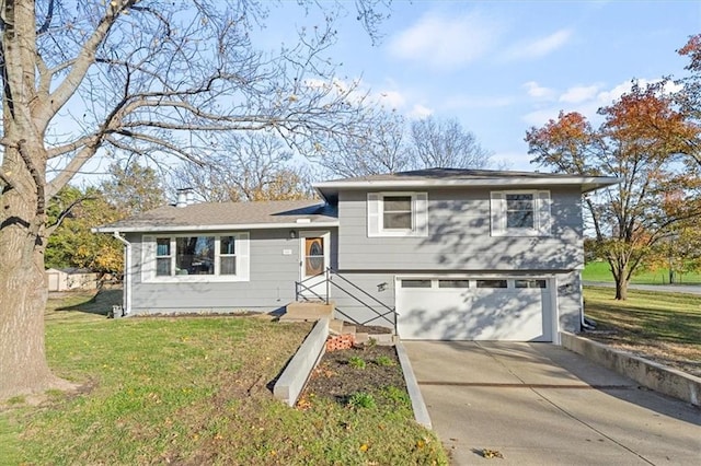 tri-level home featuring a garage and a front lawn