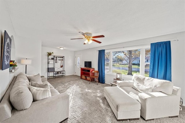 living room with ceiling fan and a textured ceiling