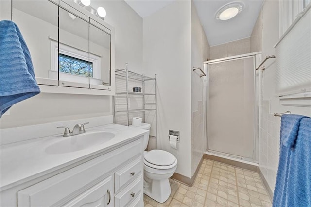 bathroom featuring vanity, toilet, and a shower with door