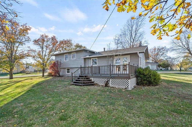 rear view of property featuring a yard and a wooden deck