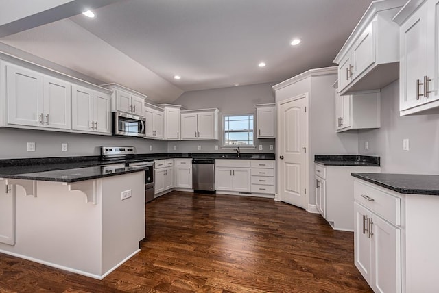 kitchen with white cabinets, appliances with stainless steel finishes, and dark hardwood / wood-style flooring