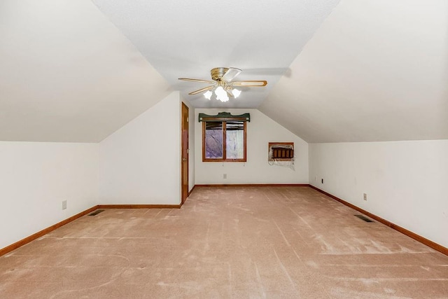 additional living space with ceiling fan, light colored carpet, and lofted ceiling