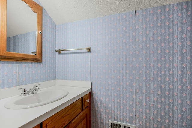 bathroom featuring a textured ceiling and vanity