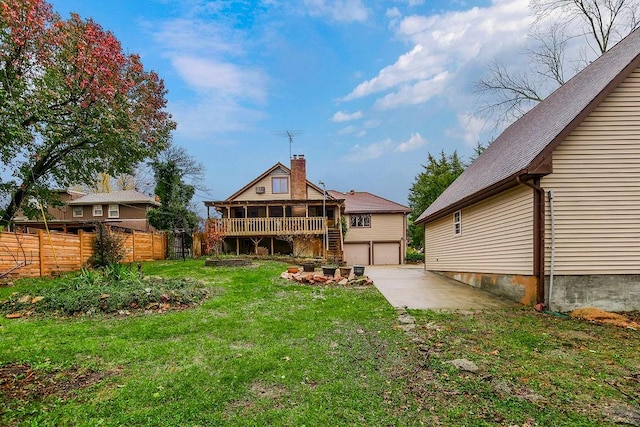 rear view of house featuring a deck and a lawn