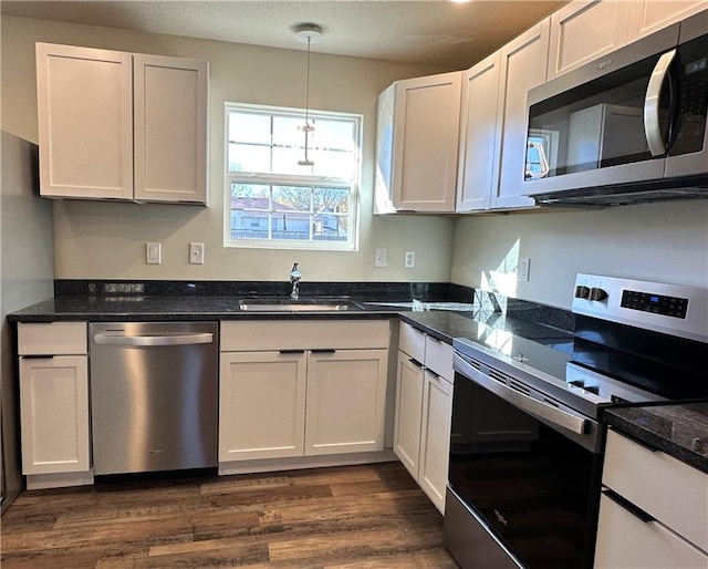 kitchen featuring dark wood-type flooring, white cabinets, stainless steel appliances, and sink