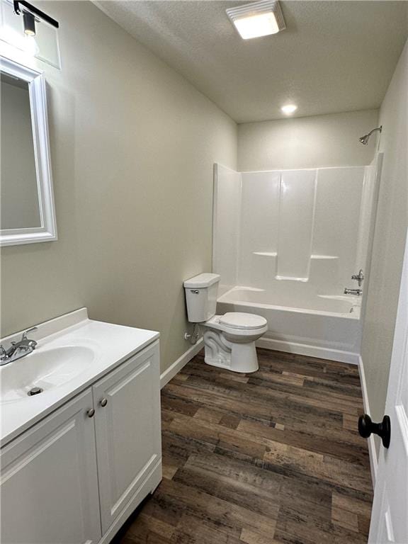 full bathroom featuring vanity, toilet, wood-type flooring, and bathtub / shower combination