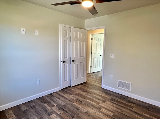 unfurnished bedroom featuring a closet, ceiling fan, and dark wood-type flooring