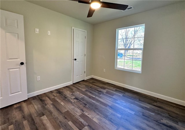 spare room with dark hardwood / wood-style floors and ceiling fan