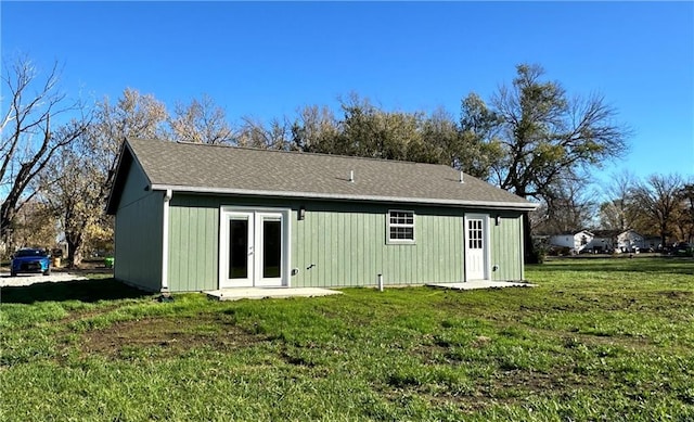 back of house with french doors and a yard