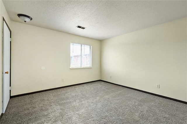 carpeted spare room featuring a textured ceiling