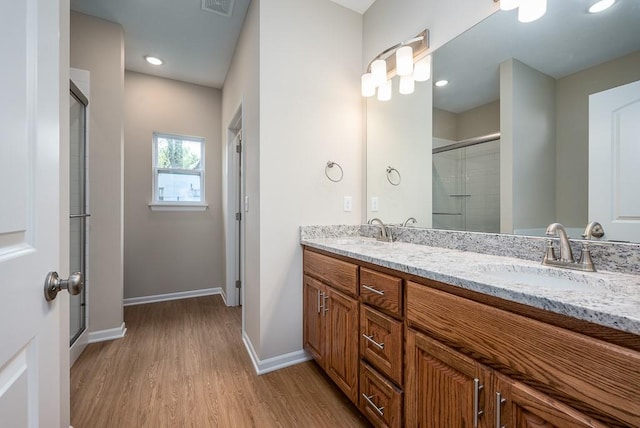 bathroom featuring vanity, hardwood / wood-style flooring, and a shower with door