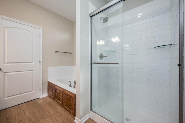 bathroom with hardwood / wood-style flooring and separate shower and tub