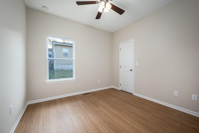 empty room with hardwood / wood-style floors and ceiling fan