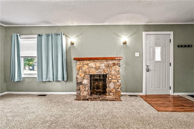 living room featuring a stone fireplace, carpet, and a textured ceiling