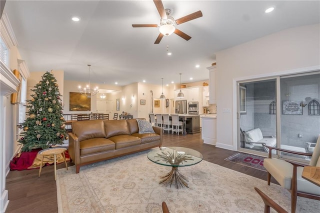 living room featuring dark hardwood / wood-style floors and ceiling fan with notable chandelier