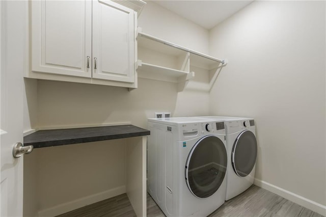 washroom featuring light hardwood / wood-style floors, cabinets, and independent washer and dryer