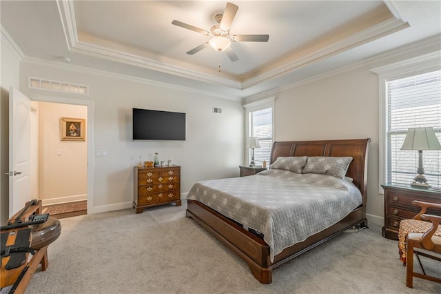 bedroom with a tray ceiling, ceiling fan, light carpet, and ornamental molding