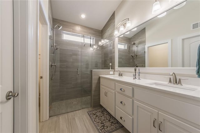 bathroom with hardwood / wood-style flooring, vanity, and walk in shower