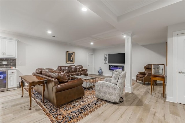 living room with light hardwood / wood-style floors, ornamental molding, wine cooler, and bar area