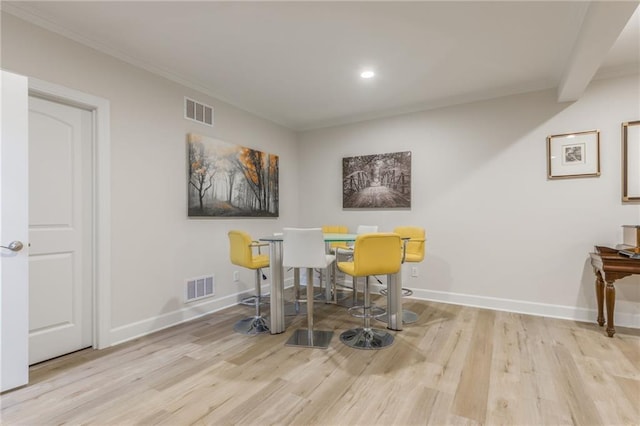 dining area featuring light hardwood / wood-style flooring and crown molding