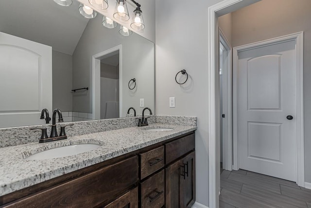 bathroom with vanity, wood-type flooring, and lofted ceiling