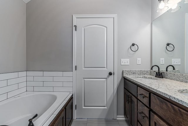 bathroom with a tub, tile patterned flooring, and vanity