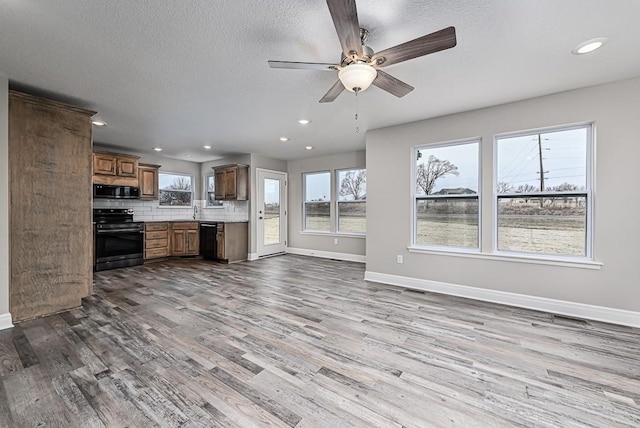 kitchen featuring black appliances, ceiling fan, light hardwood / wood-style floors, and backsplash