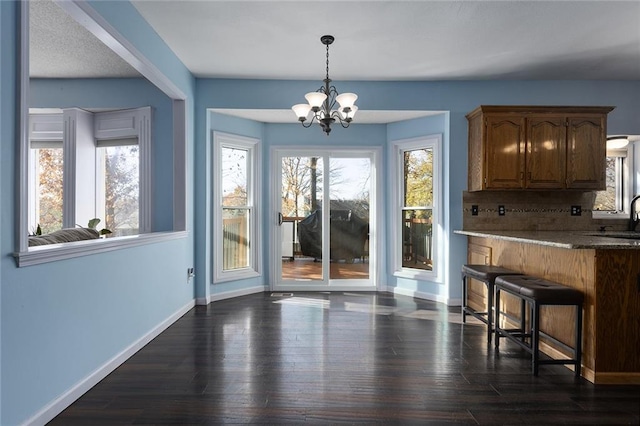 dining space featuring a notable chandelier, dark hardwood / wood-style flooring, and sink