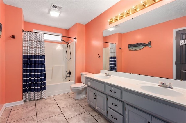 full bathroom featuring vanity, a textured ceiling, shower / tub combo with curtain, and toilet