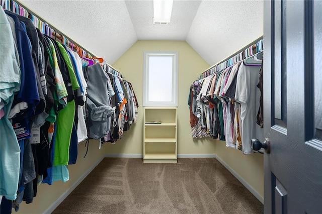 walk in closet with carpet and vaulted ceiling