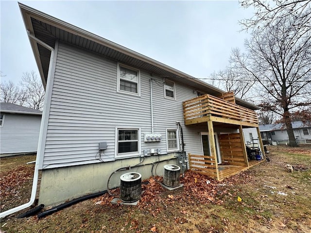 back of property with a balcony and central AC