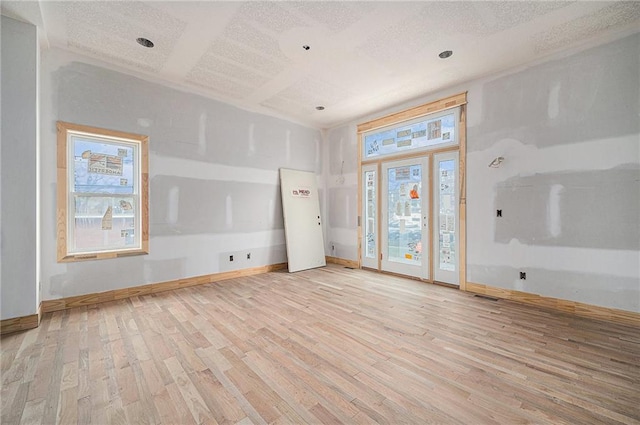 unfurnished room featuring light hardwood / wood-style floors and a textured ceiling