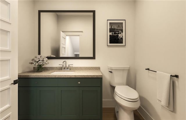 bathroom featuring vanity, hardwood / wood-style flooring, and toilet