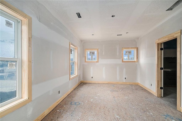 unfurnished room featuring a textured ceiling