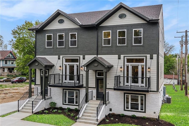 multi unit property with cooling unit, a front lawn, and a balcony