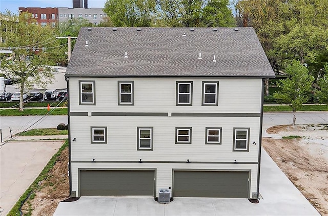 exterior space featuring driveway, cooling unit, and a garage