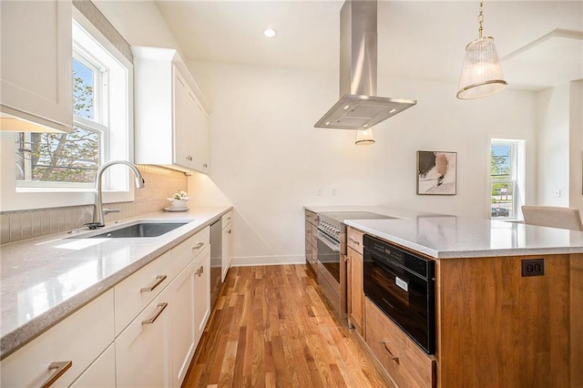 kitchen featuring a sink, stainless steel appliances, island exhaust hood, light wood-type flooring, and white cabinets