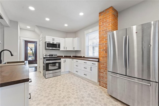 kitchen featuring white cabinets, plenty of natural light, sink, and appliances with stainless steel finishes