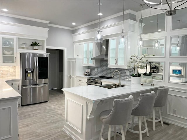 kitchen featuring a breakfast bar, sink, light stone countertops, white cabinetry, and stainless steel appliances